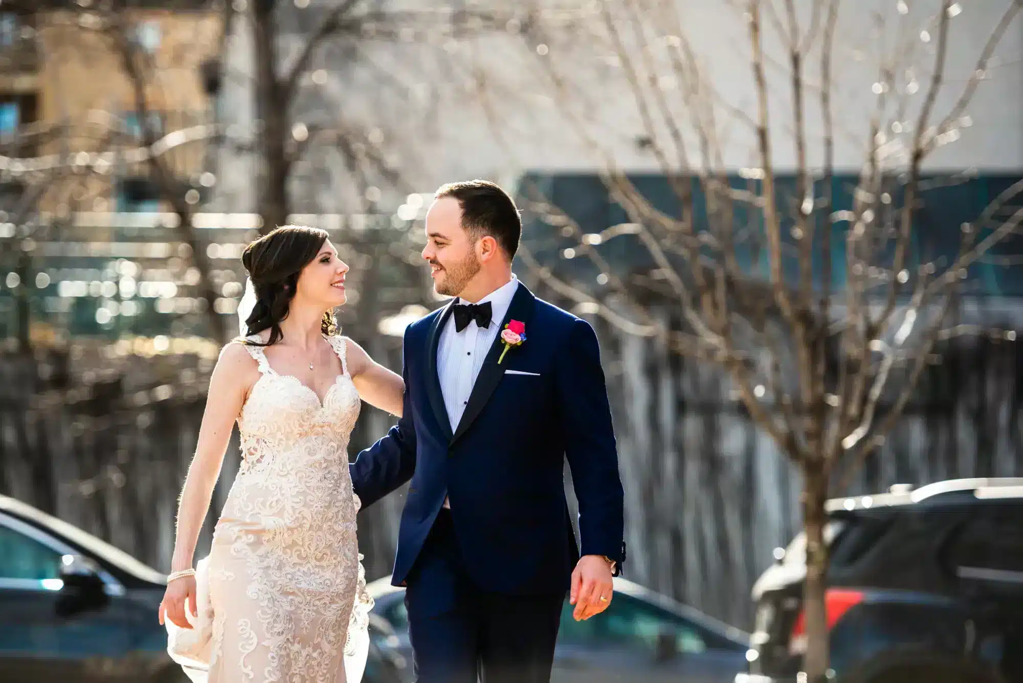bride and groom walking together smiling outside Fort Garry hotel